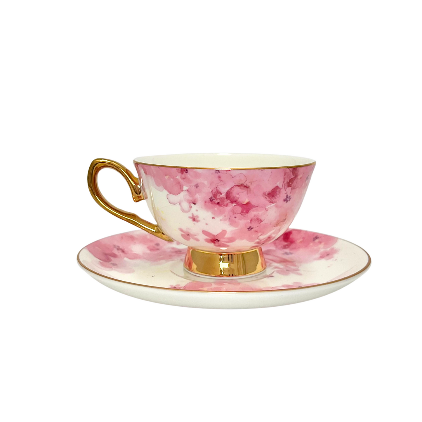 Teacup with pink flowers on a white background with gold handle and edges. Teacups is sitting on matching pink flower saucer. Isolated on a white background.